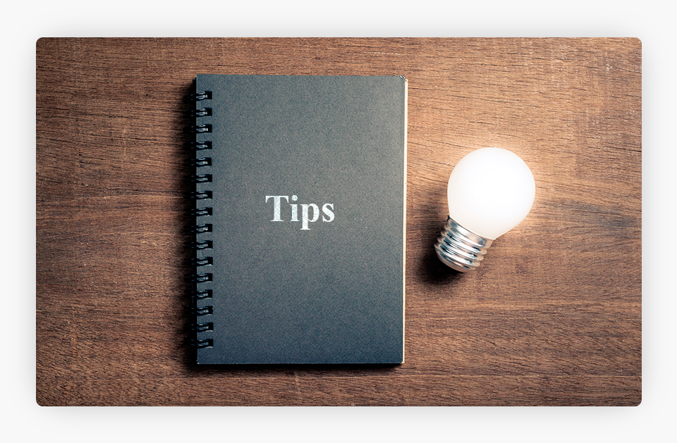 Tips Notebook Next to Lit Lightbub