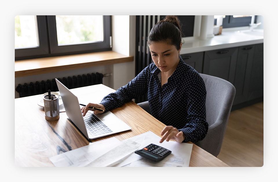 Person Checking a Computer and a Calculator