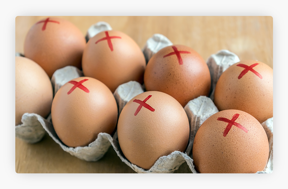 Brown farm eggs with a red cross in a white carton.