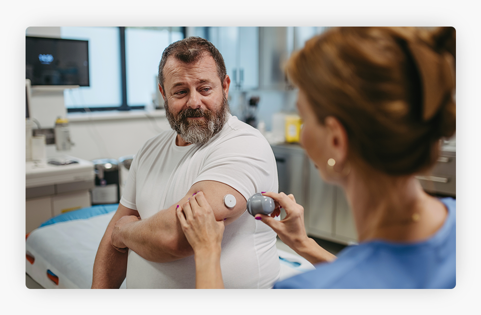 The doctor applied a continuous glucose monitor sensor on the patient's arm