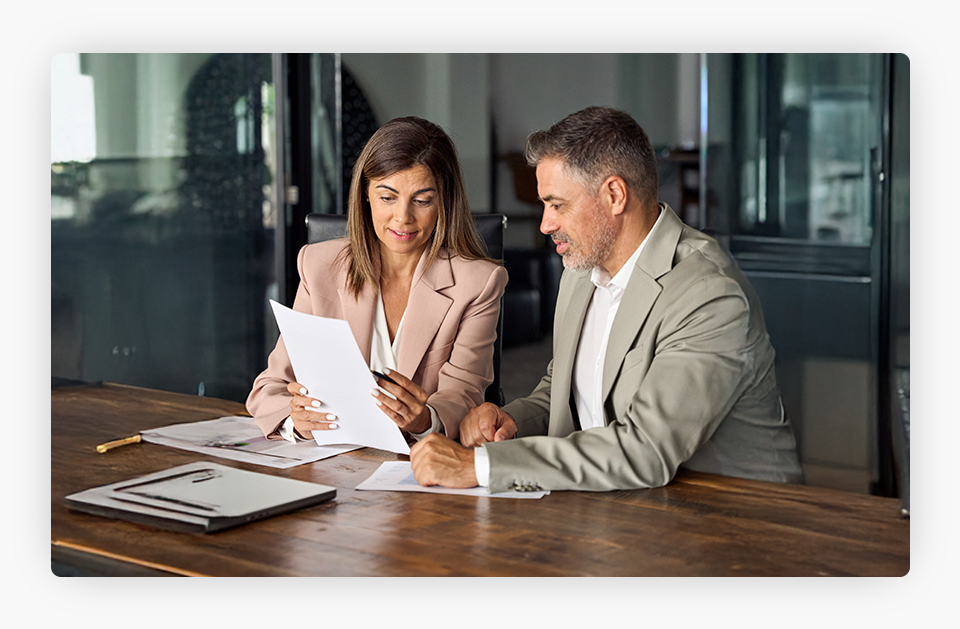 Female lawyer holding legal documents while consulting with a client.