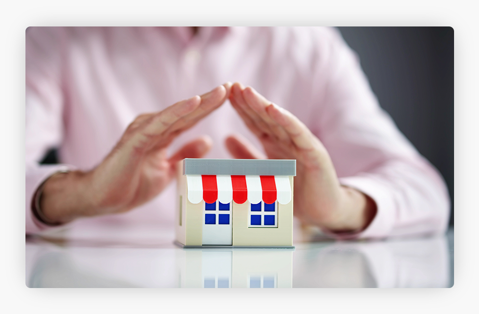 A small store being protected by a person's hands