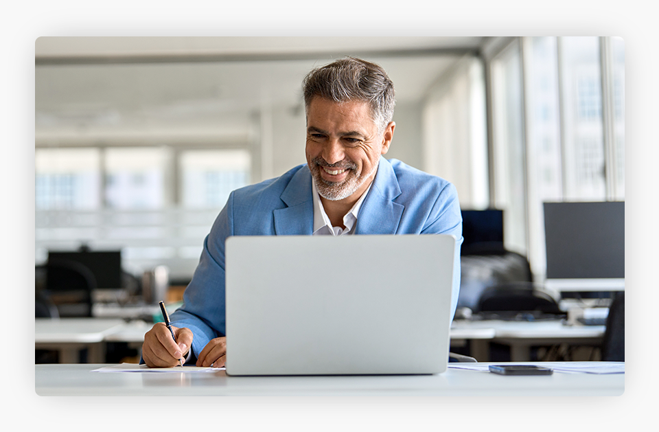 A person smiling at a computer.