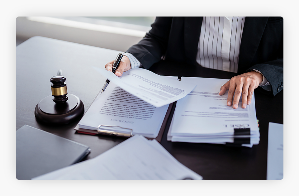 A person looking at some documents and papers next to a gavel.